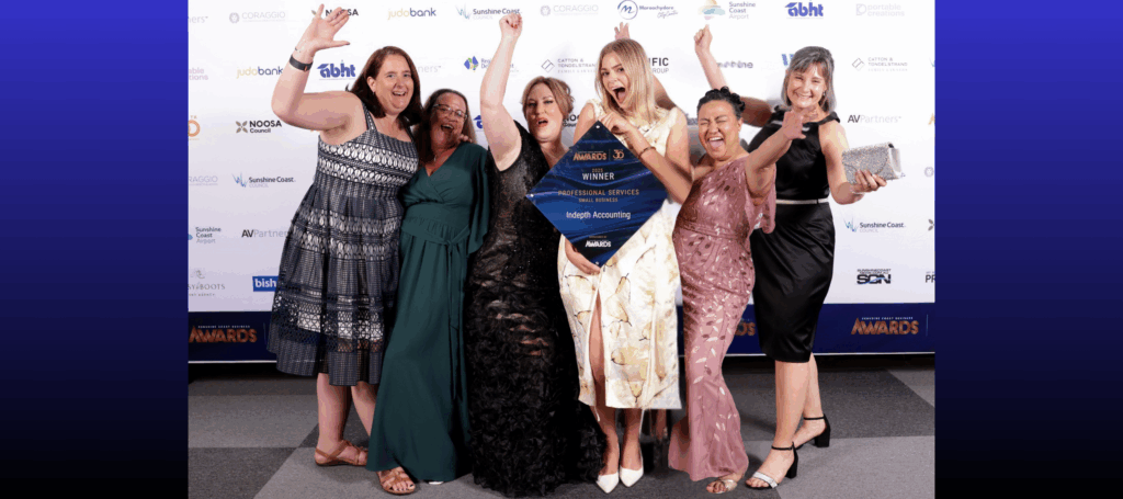 Indepth Accounting staff pose for the camera, cheering after their win and holding the plaque for the Professional Services Award at the 2025 Sunshine Coast Business Awards.