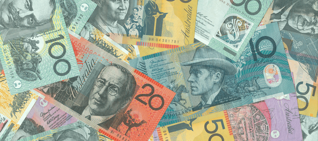 A close-up of all denominations of Australian notes spread over a surface.